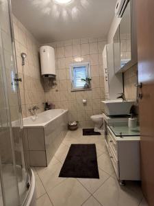 a bathroom with a sink and a tub and a toilet at Kuća za odmor Antonini in Kaštela