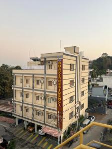 um grande edifício branco com um sinal amarelo em SRI BHAVYARESIDENCY em Bhadrachalam