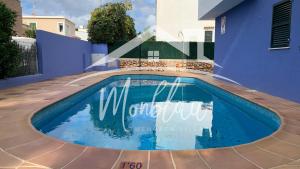 a swimming pool in front of a blue building at SA TORRETA 1 in Cala Blanca