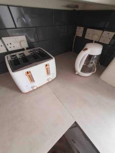 a white toaster sitting on a counter in a kitchen at Stylish 2 Bedroom Maisonette in the heart of Gloucester Road in Bristol