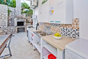a kitchen with a counter with a sink and a fireplace at Luka's Lodge Guesthouse & Hostel in Hvar