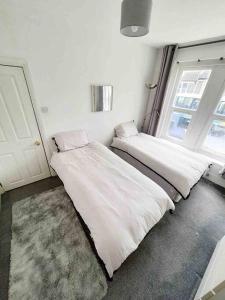 two beds in a room with a window at Stylish 2 Bedroom Maisonette in the heart of Gloucester Road in Bristol