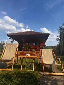 2 Stühle und ein Tisch vor einem Haus in der Unterkunft Studio Vikendica Bele Vode in Banja Koviljača