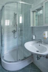 uma casa de banho com uma cabina de duche em vidro e um lavatório. em Bed and Breakfast Rooms Sandalj em Mošćenička Draga