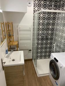 a bathroom with a shower and a sink and a washing machine at Le refuge du Touvet in Le Touvet