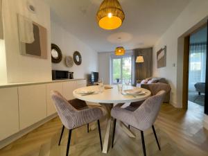 een keuken en een woonkamer met een tafel en stoelen bij La Maison Régent & spa face à la mer in Pornichet