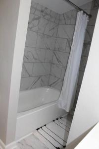 y baño con bañera y cortina de ducha. en NEW Bright & Modern 3BR// Conveniently Located//Toledo Stones Throw, en Toledo