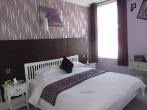 a bedroom with a large bed with white sheets and pillows at FourRooms - Couples Only in Blackpool