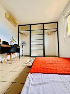 - une chambre avec un lit, un bureau et un piano dans l'établissement Appartement Badja, à Tsingoni
