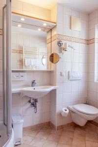 ein Bad mit einem Waschbecken und einem WC in der Unterkunft Hotel Weisser Bär in St. Wolfgang