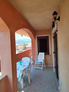 Zimmer mit einem Balkon mit Stühlen und einem Tisch in der Unterkunft La Stella Marina in Bari Sardo