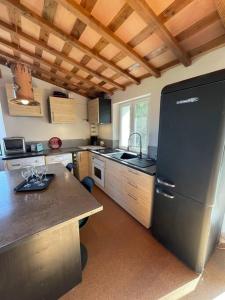 eine Küche mit einem schwarzen Kühlschrank und einer Theke in der Unterkunft Gîtes Bois-Mariage in Veaux