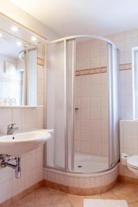 uma casa de banho com um chuveiro e um lavatório. em Hotel Weisser Bär em St. Wolfgang