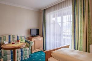 a hotel room with a bed and a table and a tv at Hotel Weisser Bär in St. Wolfgang