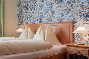 a bedroom with two beds with blue and white wallpaper at Hotel Weisser Bär in St. Wolfgang
