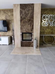 a living room with a fireplace and a tile floor at Bungalov Valentýna in Mikulov