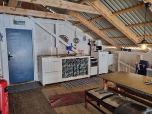 uma cozinha com um fogão, uma mesa e uma porta em Boathouse em Mjällom