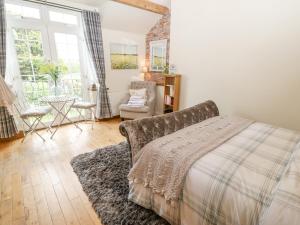 a bedroom with a bed and a chair and window at The Nutshell in Chester-le-Street