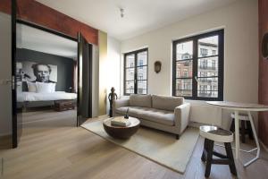 ein Wohnzimmer mit einem Sofa und einem Bett in der Unterkunft Smartflats Premium - Palace du Grand Sablon in Brüssel