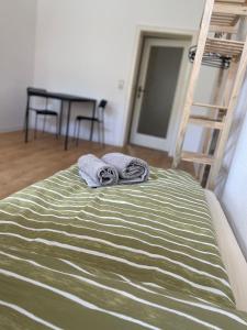 uma cama com um cobertor verde e branco e uma escada em Apartment am Kino em Bautzen