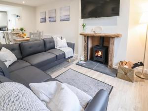 a living room with a couch and a fireplace at 4 Railway Terrace in Conwy