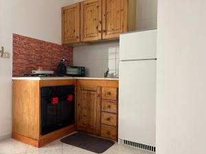 eine Küche mit einem weißen Kühlschrank und Holzschränken in der Unterkunft Calamaterdomini a 2 passi dal mare in Brindisi