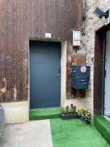 a blue door on a building with green grass at Le refuge du Touvet in Le Touvet