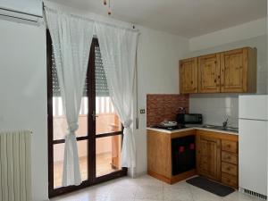 a kitchen with a sliding glass door to a balcony at Calamaterdomini a 2 passi dal mare in Brindisi