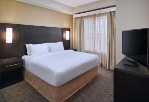 a bedroom with a large bed and a flat screen tv at Residence Inn Fort Lauderdale SW/Miramar in Miramar