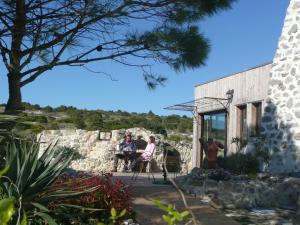 two people sitting in chairs outside of a building at Domaine Castelsec in Roquefort-des-Corbières