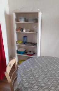 a room with a table and a shelf with dishes at Studio intra-muros 5mn gare centre in Avignon