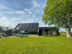 WijdenesにあるVakantiehuis Het Uilennestの屋根に太陽光パネルを敷いた家