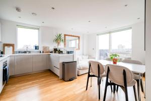 a kitchen and living room with a table and chairs at Modern Bermondsey Apartment in London