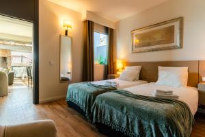 a hotel room with a bed and a large window at Calheta Tangerine House in Arco da Calheta