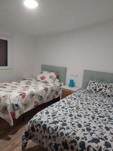 two beds sitting next to each other in a bedroom at Apartamento en casa Portonovo vacaciones in Portonovo