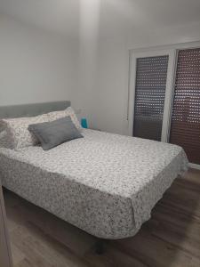 Apartamento en casa Portonovo vacaciones في بورتونوفو: غرفة نوم عليها سرير ومخدة