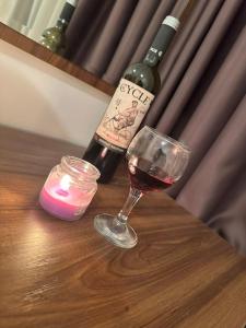 a glass of wine and a candle on a table at Aspen Luxury Apartamnet in Razlog