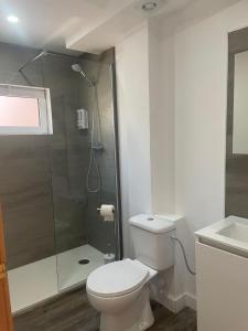 a white bathroom with a toilet and a shower at Piso en el centro del Vendrell. Alojamiento entero. in El Vendrell