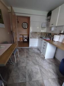 une cuisine avec des placards blancs, une table et une salle à manger dans l'établissement APARTAMENT nad Kanałem Augustowskim, à Augustów