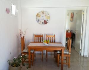 uma mesa de jantar e cadeiras com um relógio na parede em Apartamento La Aldea Pueblo Gran Canaria 2A em San Nicolás