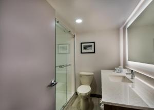 a bathroom with a toilet and a glass shower at Comfort Inn Falls Church - Tysons Corner in Falls Church