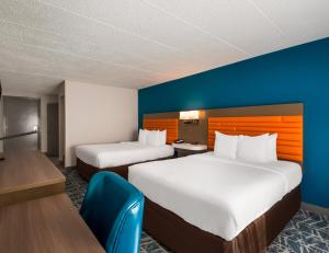 a hotel room with two beds and a blue wall at Comfort Inn Falls Church - Tysons Corner in Falls Church