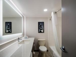 a bathroom with a toilet and a sink and a tub at Comfort Inn Falls Church - Tysons Corner in Falls Church