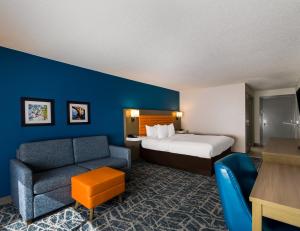 a hotel room with a bed and a chair at Comfort Inn Falls Church - Tysons Corner in Falls Church