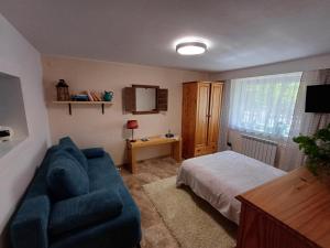 - une chambre avec un lit et un canapé bleu dans l'établissement APARTAMENT nad Kanałem Augustowskim, à Augustów