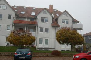 a large house with a car parked in front of it at Ferienwohnung Harländer in Petersdorf auf Fehmarn