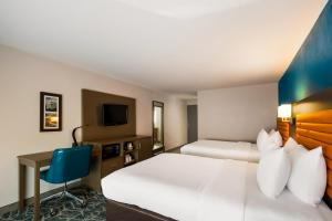 a hotel room with two beds and a desk at Comfort Inn Falls Church - Tysons Corner in Falls Church