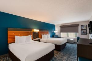 a hotel room with two beds and a desk at Comfort Inn Falls Church - Tysons Corner in Falls Church