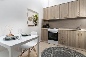 a kitchen with a white table and a white counter at Appartamento Mare calmo-Myrtos in Myrtos