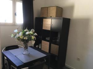 a dining room table with a vase of flowers on it at Le mazet in La Londe-les-Maures